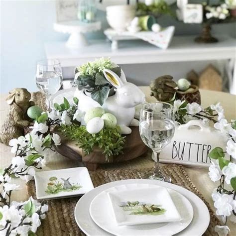 An Easter Table Setting With Bunny Figurines And Flowers