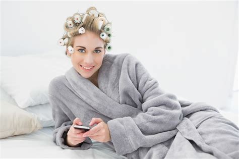 Premium Photo Pleased Relaxed Blonde Woman In Hair Curlers Using Her