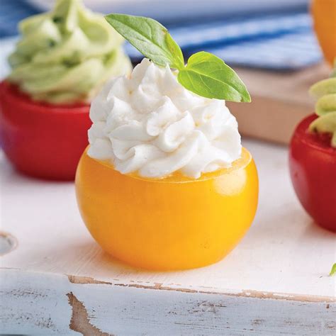 Three Small Tomatoes With Whipped Cream And Green Leaves On Top