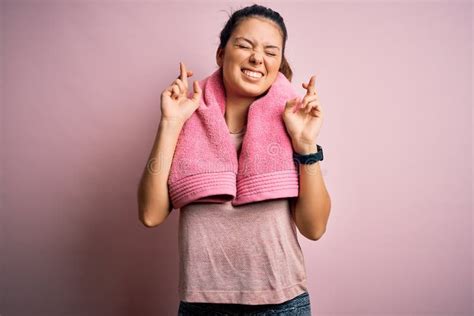 Joven Y Hermosa Deportista De Brunette Con Ropa Deportiva Y Toalla Sobre Fondo Rosa Haciendo