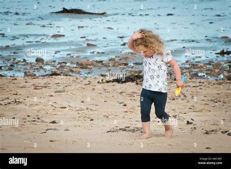 Little girl exploring the beach Stock Photo - Alamy