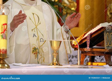 Chalice On The Altar And Priest Celebrating Mass In The Background