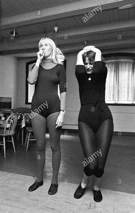 Two Women In Black Bodysuits Standing Next To Each Other