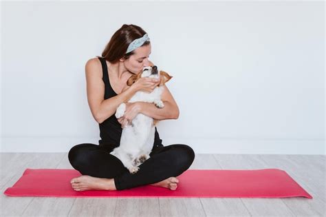 Premium Photo Woman Exercising With Dog By Wall At Home