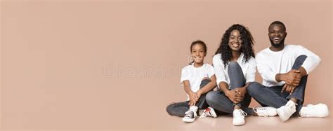 Família Negra De Três Sentadas No Chão Em Pose Parecida Foto de Stock