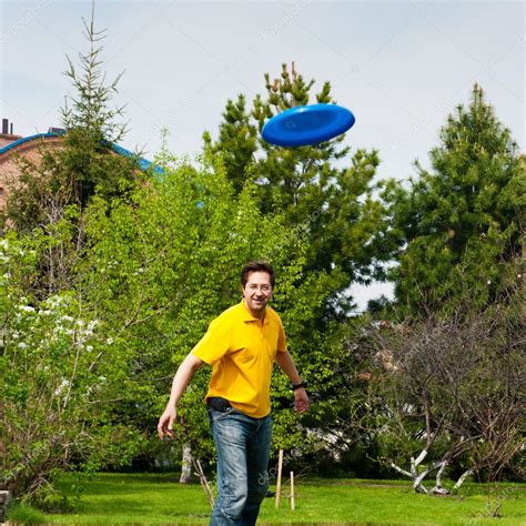 Man Playing Frisbee At His Backyard — Stock Photo © Hasloo 8773380