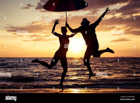 Silueta De Hombre Y Mujer Saltando En La Playa Fotograf As E Im Genes