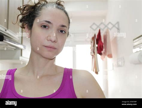 Brazilian Brunette Housewife Looking Serious At Camera In A Tiny Apartment Laundry Room