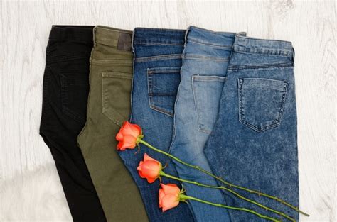 Premium Photo Five Pairs Of Jeans Of Different Colors Orange Roses