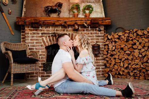 Lovers Are Sitting On Carpet In Front Of Fireplace Close Up Stock