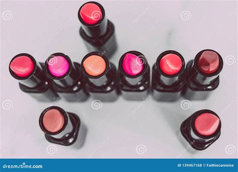 Group Of Red Pink And Nude Lipsticks With Different Colors And Textures Lined Up And Shot Top