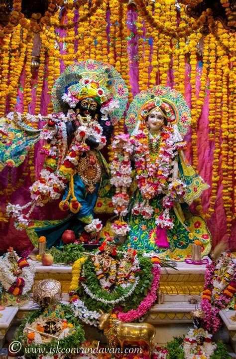 An Idol Is Displayed In Front Of Flowers And Garlands