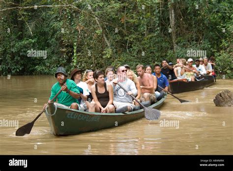 A Group Of Tourists On A Canoe Trip On A Tributary Of The Amazon River