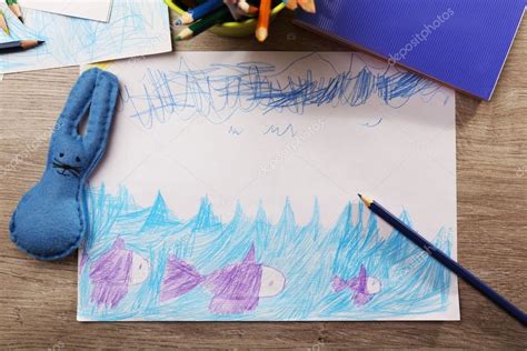 Niños dibujo en hoja blanca de papel con lápices de colores en la mesa