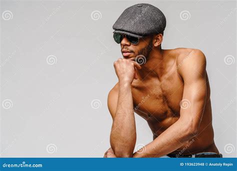 Young Muscular African American Man Shirtless Wearing Sunglasses And Cap Over Light Grey