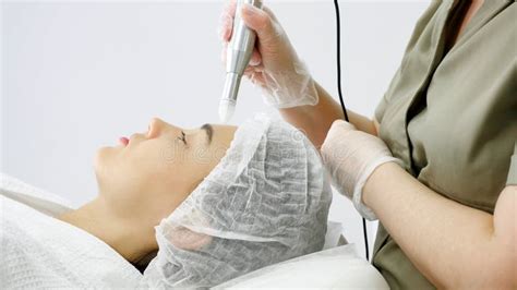 Beautician Hand Moves Microdermabrasion Device On Forehead Stock Image