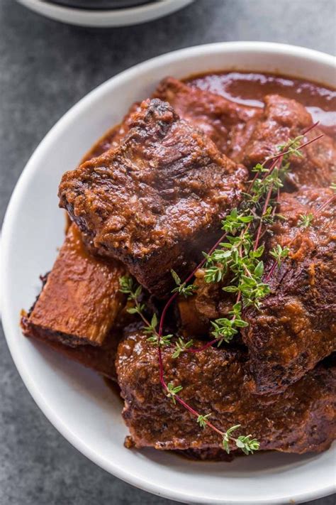 Red Wine Braised Short Ribs In A Bowl Topped With Fresh Thyme Braised