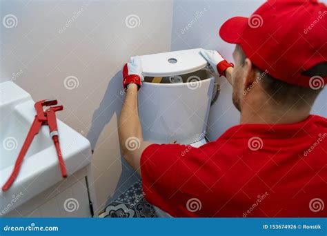 Plumbing Services - Plumber Working in Bathroom Installing Toilet Wc