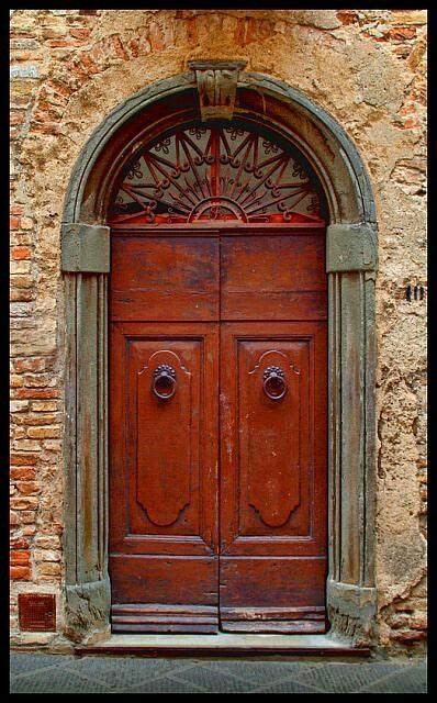 An Old Red Door With Arched Glass Above It