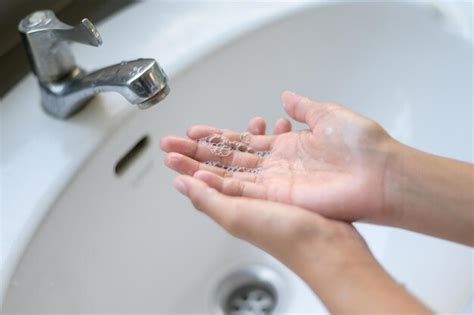 Premium Photo A Woman Washes Her Hands With Soap