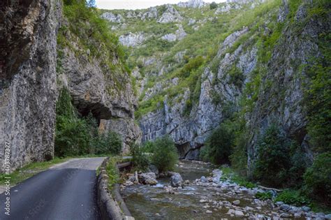 Road Passing Through Rocky Eroded Terrain Surrounded By Rocks And Lush