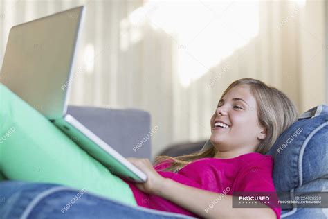 Girl Lying On Bean Bag And Using Laptop — Leaning Profile Stock