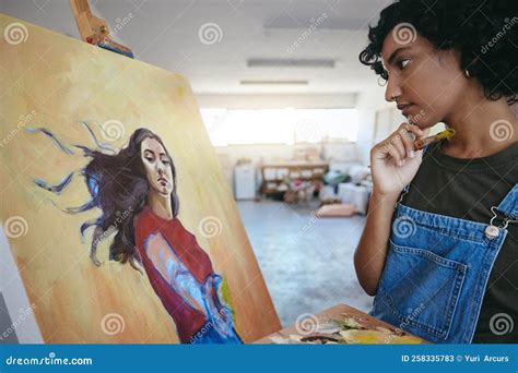 Creative Woman Thinking About Her Art And Looks At Painting In Studio