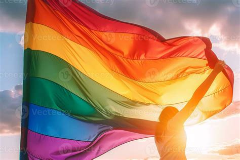 Pride Rainbow Lgbt Gay Flag Being Waved By Woman Back View In The Breeze Against A Sunset Sky