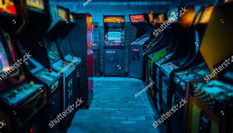 Old Vintage Arcade Video Games In An Empty Dark Gaming Room With Blue Light With Glowing