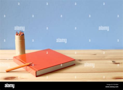 Notebook and colored pencil on wooden desk Stock Photo - Alamy