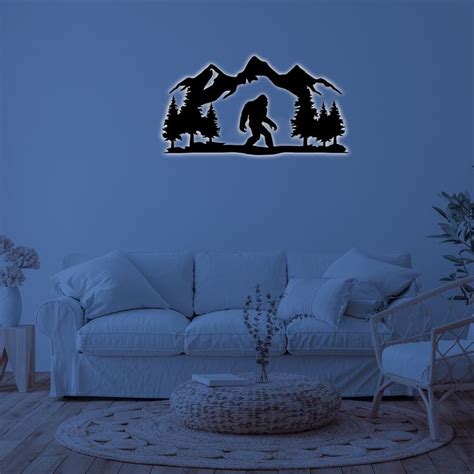 a living room with a couch, chair and wall decal in the shape of a bigfoot