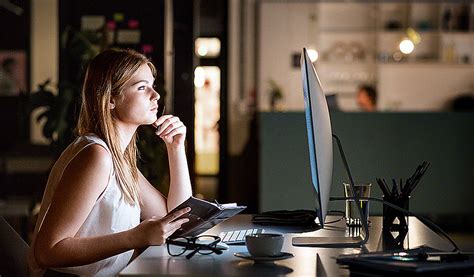 Businesswoman In Her Office At Night Working Late Reading Housebar