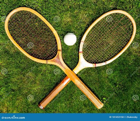 Vintage Tennis Racquets With Traditional White Ball On Grass Court