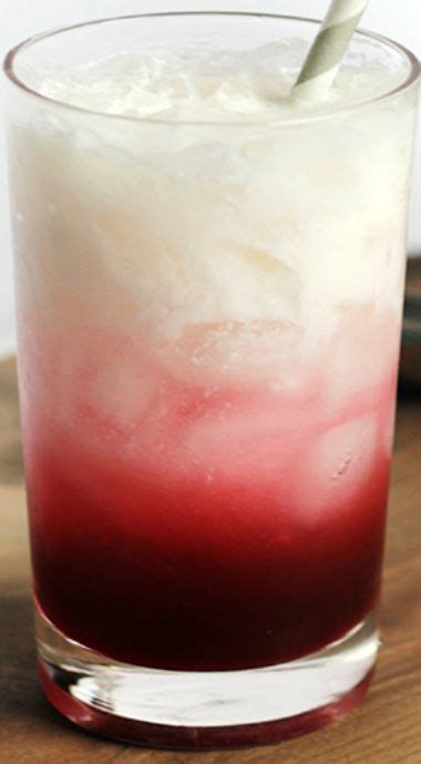 A Red And White Drink Sitting On Top Of A Wooden Table