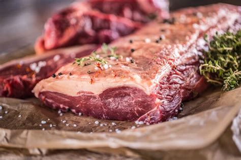 Premium Photo Raw Rib Eye Beef Steak With Salt Spices And Herbs