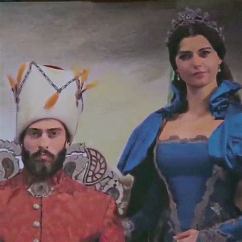 A Man And Woman Dressed Up In Renaissance Costumes Standing Next To