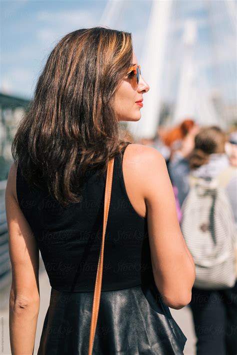 A Woman Walks On A Bridge In The City In Summer By Stocksy