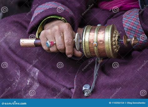 Old Hands Of A Tibetan Woman Holding Prayer Buddhist Wheel At A Hemis