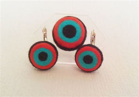 Three Pairs Of Earrings With Blue And Red Circles On The Front One In