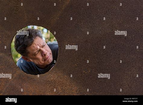 Handsome Mature Man In The Iron Plate Hole Looking At The Camera