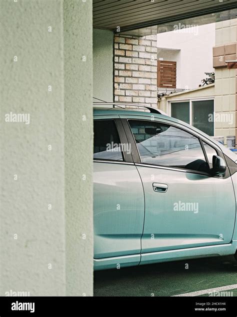 Vertical Shot Of A Blue Car In A Driveway Stock Photo Alamy