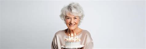 Premium AI Image | Happy beautiful old woman holding birthday cake with candles isolated on ...