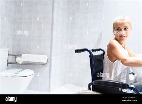 Blonde Fille Assise Dans Un Fauteuil Roulant Dans Une Salle De Bains Avec Les Toilettes Derri Re