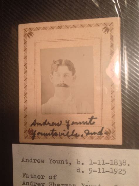 An Old Photo Is On Display In A Glass Case Next To A Paper With The