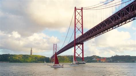 Sailboat On The Rio Tejo Under The Ponte 25 De Abril In Lisbon