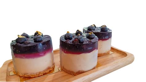 Cheesecake With Black Currant And Blueberry Sauce On Wooden Plate On A