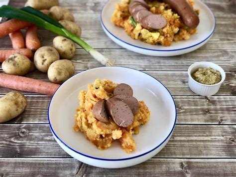 Two White Plates With Food On Them Next To Some Carrots And Other Veggies