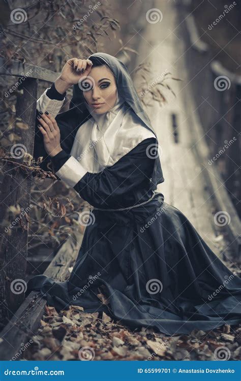 Seductivesexual Nun Sits On The Wooden Bridge Outdoors And Pray Forsexual Nun With Creative