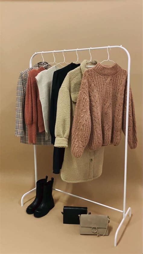 An Ironing Board With Sweaters And Boots Hanging On It S Clothes Rack