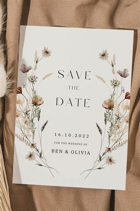 A Wedding Save The Date Card With Wildflowers And Feathers On It Next